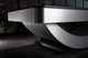Close-up half view of the Doc & Holliday Poshy Reverse Rainbow Slate Pool Table leg base, showcasing the brushed silver metallic frame, reverse rainbow gradient detail, and matte black upper rails. Close-up half view of the Doc & Holliday Poshy Reverse Rainbow Slate Pool Table leg base, showcasing the brushed silver metallic frame, reverse rainbow gradient detail, and matte black upper rails.